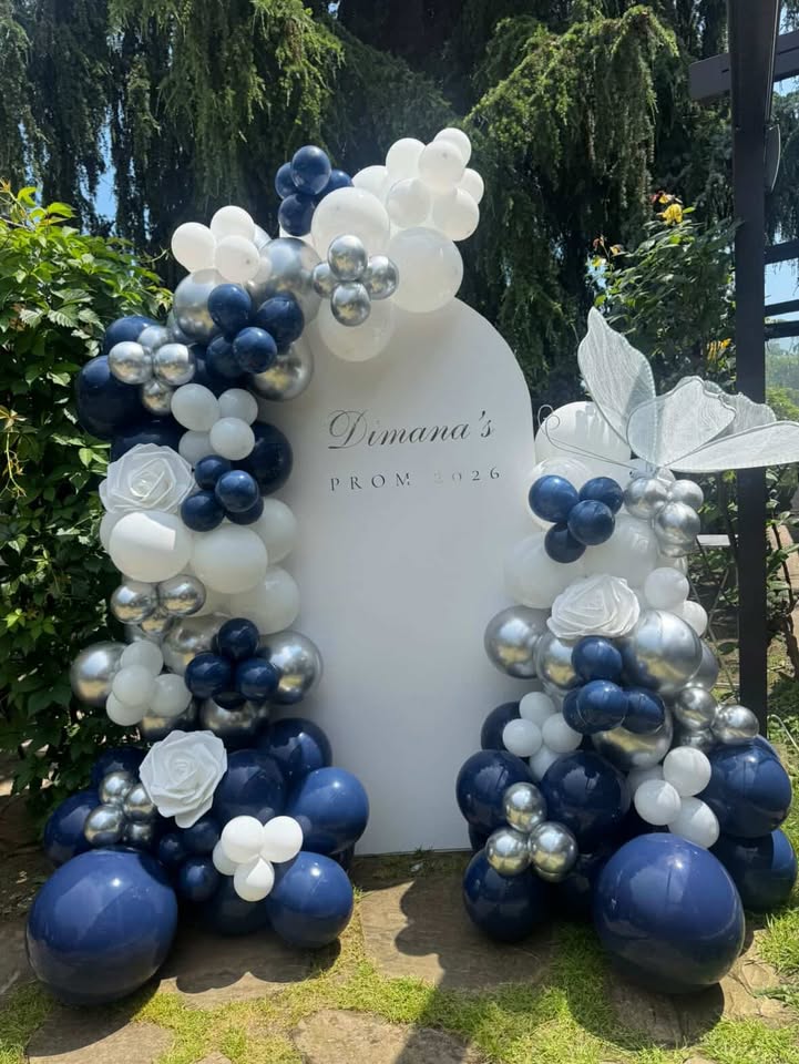 Blue, white, and silver balloon decor around a white arched backdrop