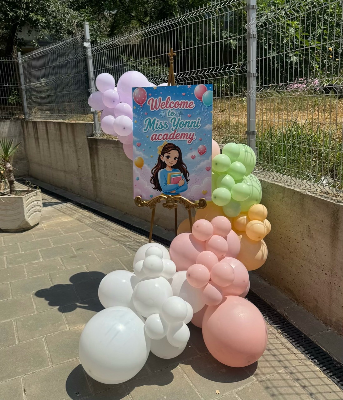 Welcome sign with pastel balloon clusters and children's academy decor